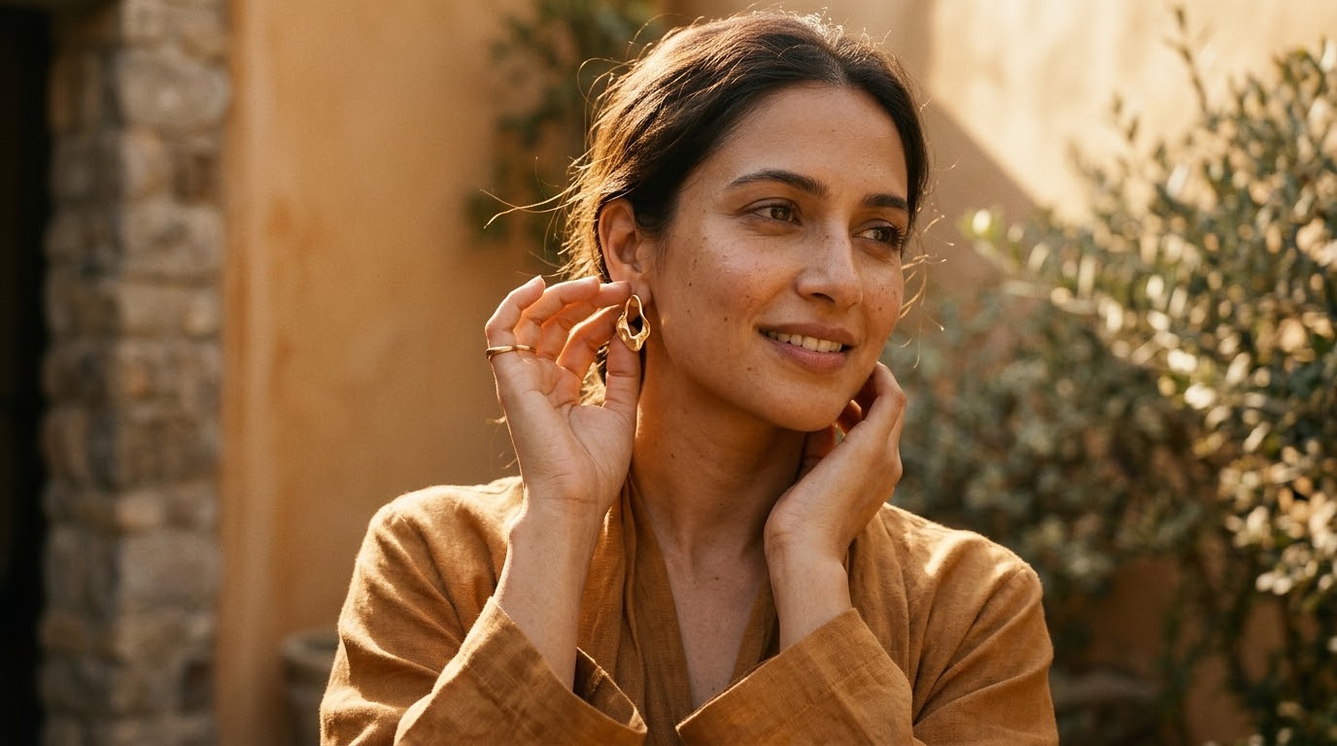 The Bazzaro Moment - Modern Indian woman in golden hour sunlight wearing sculpted gold earring